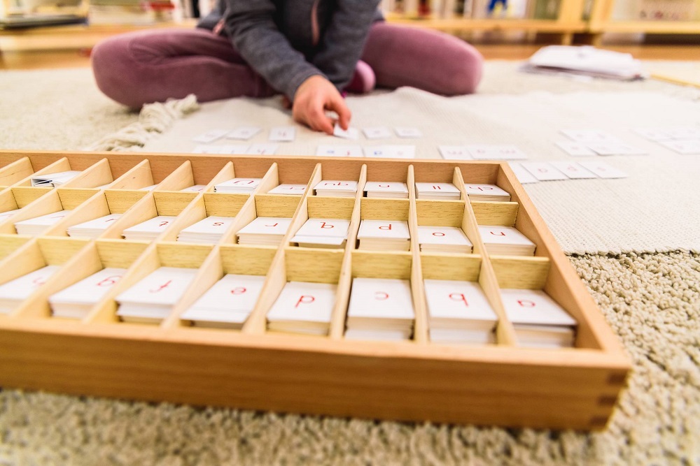 Enfant qui joue à une activité Montessori 3-4 ans