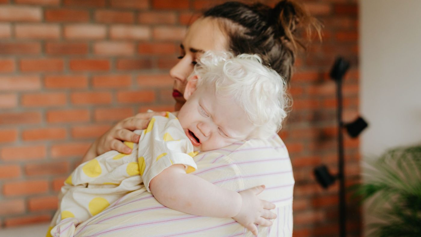 Une mère berce contre son épaule un bébé qui pleure