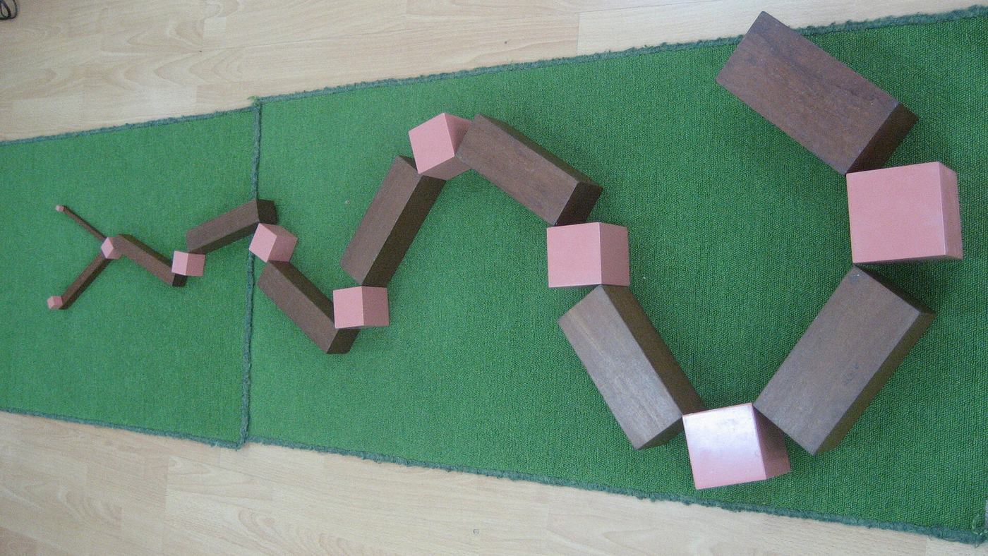 Cubes de la tour rose et prismes de l'escalier marron combinés en serpentin sur un tapis